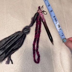 Pink and black resin self-defense keychain with white feather